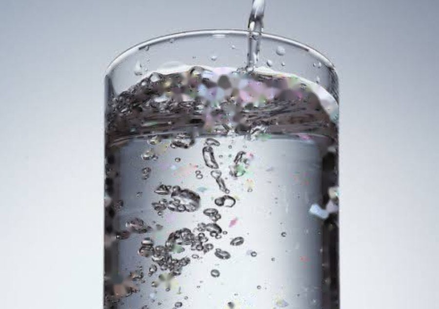 A tall glass of clean-looking water; a single drop magnified under a microscope reveals a parasite